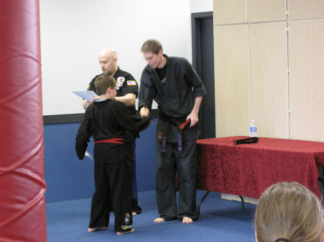 Zach receives his belt and certificate from Mr. Baker.